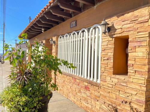 um edifício de tijolos com um portão branco e uma planta em Jaguar Studio em Tijuana
