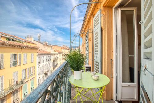 une table verte sur un balcon avec une plante dans l'établissement Massena Street - 1 Bdr Duplex with AC & Parking, à Nice
