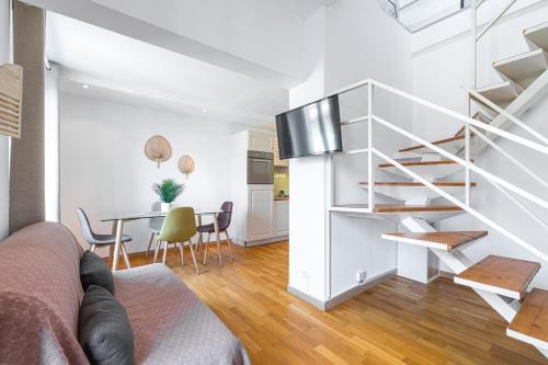 - un escalier blanc dans un salon avec une table dans l'établissement Massena Street - 1 Bdr Duplex with AC & Parking, à Nice