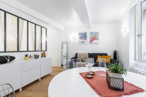un salon blanc avec une table et des chaises dans l'établissement Quiet and cosy 1bdr in Vieux Nice!, à Nice