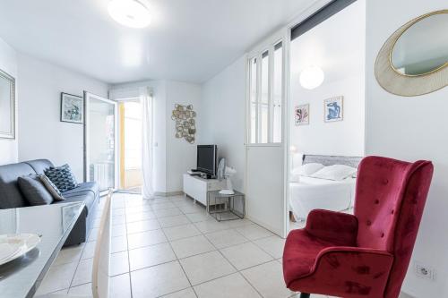 a living room with a red chair and a bed at Quiet 1 bdr Port! close Place du Pin Garibaldi in Nice