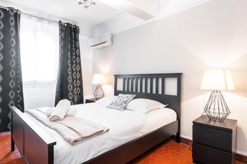 une chambre avec un lit avec des draps blancs et des oreillers dans l'établissement Large 3 Bdr Old Town - AC, à Nice
