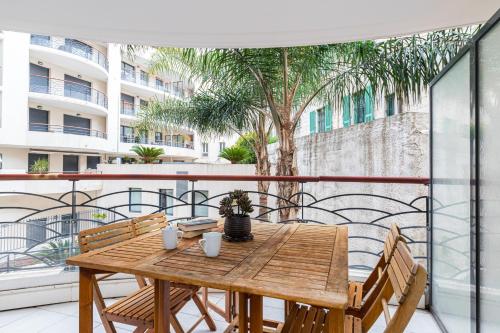 d'un balcon avec une table en bois et des chaises. dans l'établissement Nice 1 Bedroom downtown Carré d'Or with garage, à Nice
