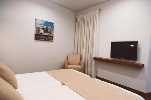 um quarto de hotel com uma cama e uma televisão em Ferreira Hostal Boutique em Conil de la Frontera
