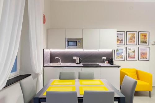 eine Küche mit einem Tisch, Stühlen und einem Waschbecken in der Unterkunft JOIVY The Place To Be in the Centre of Genoa in Genua