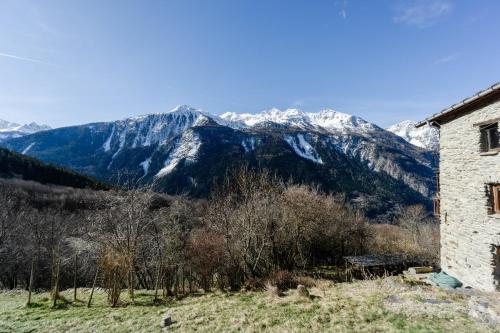 an old building with snow covered mountains in the background at Grand Chalet Vanoise - 12 pers in Saint-André