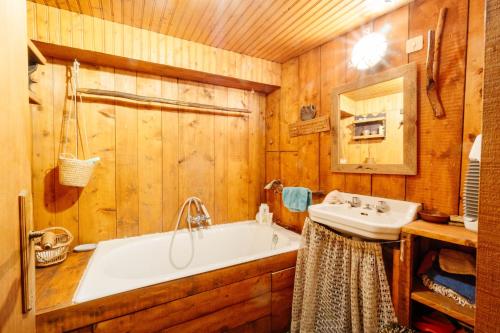 een badkamer met een bad en een wastafel bij Grand Chalet Vanoise - 12 pers in Saint-André