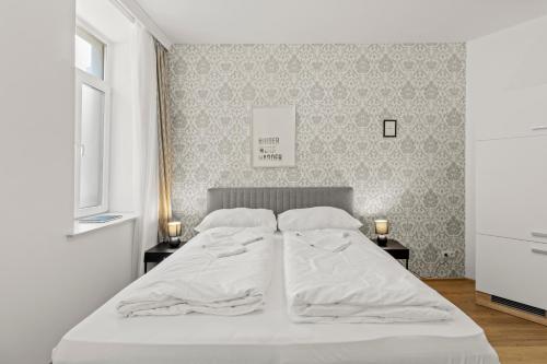 1 dormitorio con 1 cama blanca y 2 mesitas de noche en StayEasy Apartments Vienna A#2, en Viena