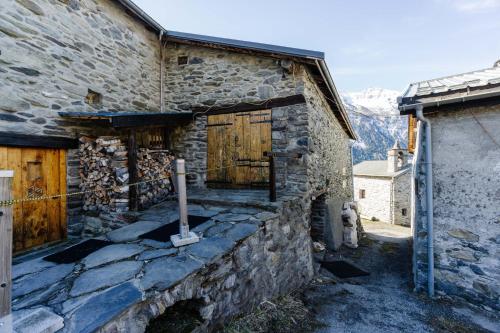 a stone building with wooden doors and a fire hydrant at Grand Chalet Vanoise - 12 pers in Saint-André