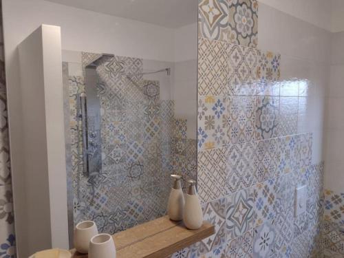 baño con ducha y 2 jarrones en un estante en Soverato con Vista, en Soverato Marina