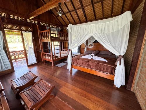 1 dormitorio con 1 cama con dosel en Orangutan Orchard Bungalow, en Timbanglawang