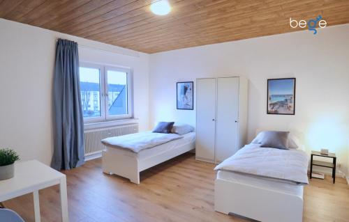 1 Schlafzimmer mit 2 Betten und einem Fenster in der Unterkunft BEGE APARTMENTS: WORK HEAVEN in Gelsenkirchen