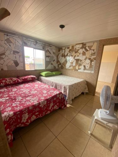 a bedroom with two beds and a chair in it at Flats com cozinha in Feira de Santana