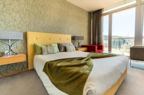 1 dormitorio con 1 cama grande y cabecero amarillo en Hotel Santa Margarida, en Oleiros