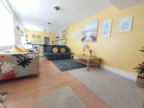 a living room with a couch and a table at Beautiful Two Bedroom ground floor apartment in Swansea