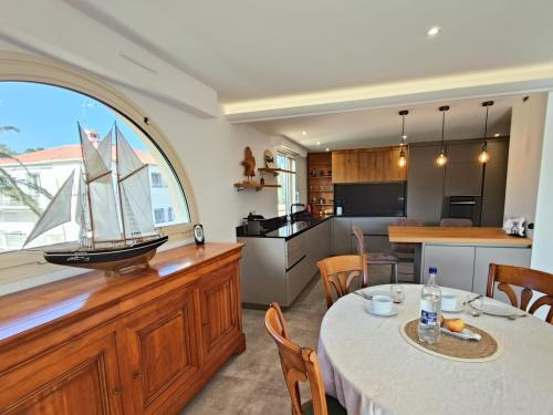 una cocina con mesa y un velero en una barra en Soleil Soleil, Villa sur le toit grande terrasse, en Saint-Raphaël