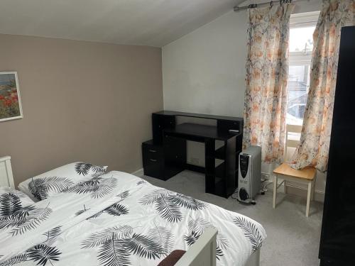 a bedroom with a bed and a desk in it at Rahal Compton in London