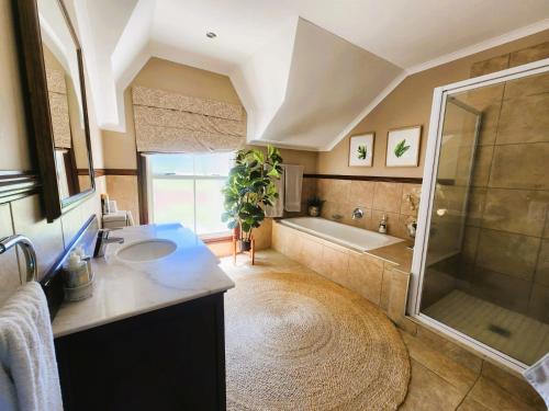 a bathroom with a tub and a sink and a shower at Main Home 4 Rawdons Estate in Nottingham Road