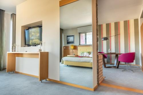 a bedroom with a bed and a desk and a mirror at Hotel Santa Margarida in Oleiros