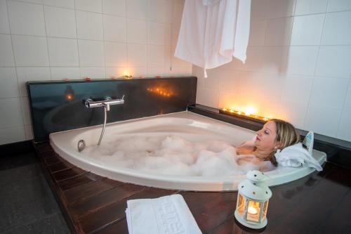 a young girl laying in a bath tub at Hotel Santa Margarida in Oleiros