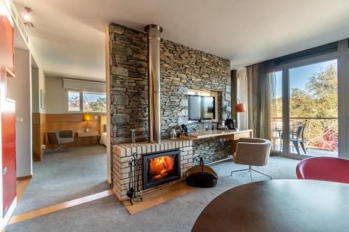 a living room with a fireplace and a television at Hotel Santa Margarida in Oleiros