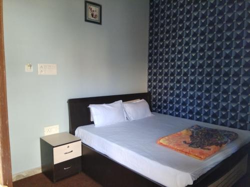 a bedroom with a bed with a blue patterned wall at Hotel zamarrud palace in Jaipur