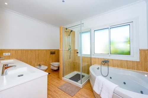 een badkamer met een bad, een douche en een toilet bij Villa Santo Sol by Villa Plus in Santa Fe de los Boliches