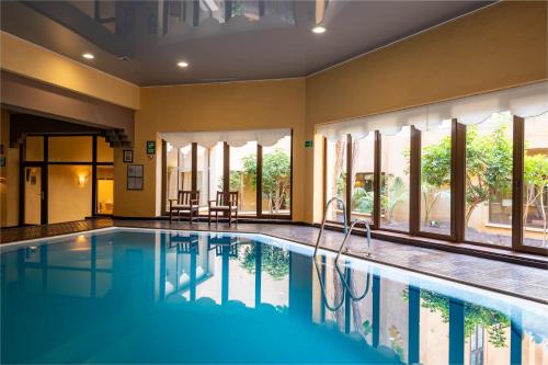 a swimming pool in a house with windows at Vila Gale Isla Canela in Isla Canela