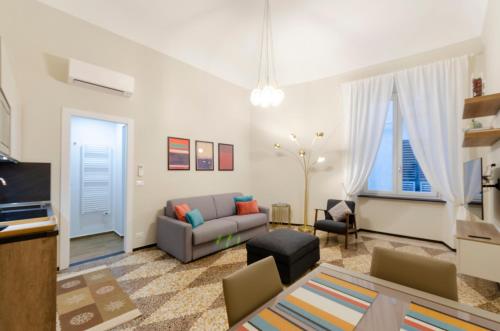 ein Wohnzimmer mit einem Sofa und einem Tisch in der Unterkunft JOIVY The Place To Be in the Centre of Genoa in Genua