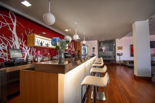 a bar with a row of stools in a restaurant at Hotel Santa Margarida in Oleiros
