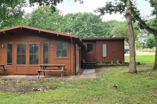 a small cabin with a picnic table in front of it at Cabin in the countryside in Sible Hedingham