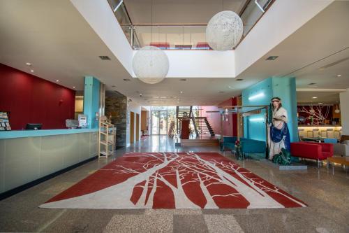 a woman standing in a lobby with a rug on the floor at Hotel Santa Margarida in Oleiros