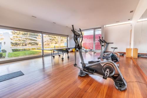 a gym with two exercise bikes in a room with wood floors at Hotel Santa Margarida in Oleiros