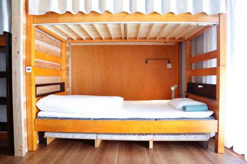a bedroom with two bunk beds with white sheets at Ise Guest House Sora in Ise