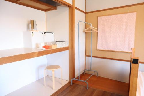 a room with a table and a stool and a window at Ise Guest House Sora in Ise