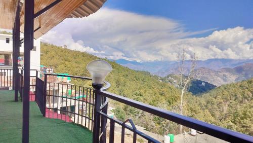a lamp on a balcony with a view of mountains at Baikunth Homes in Dalhousie