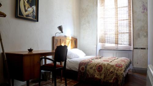 1 dormitorio con cama, escritorio, mesa y silla en Romy's Room - ensuite in shared Village Chateau, en Chalabre