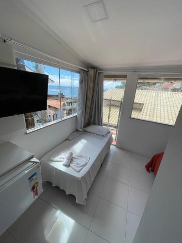 a small room with a bed and a large window at Flat Morro e Casa Blanca in Morro de São Paulo