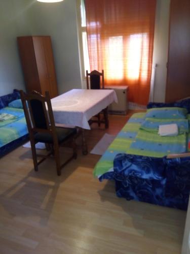a room with two beds and a table and chairs at Soba Macva in Banja Koviljača