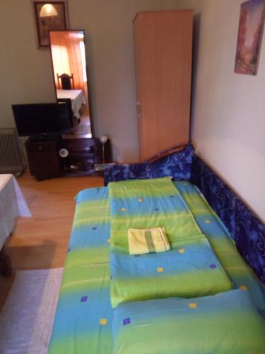 a bedroom with a bed with a blue bedspread at Soba Macva in Banja Koviljača