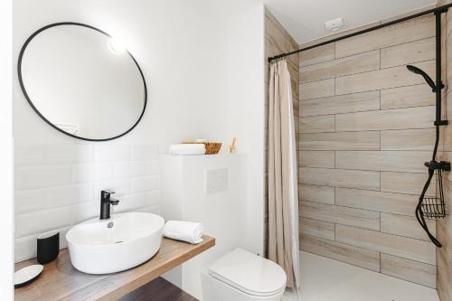 y baño con lavabo blanco y espejo. en Le Phare, Studio vue mer, en Rivedoux-Plage