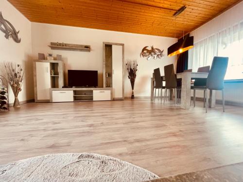 a living room with a table and a dining room at Gemütlicher Bungalow am Fuße der Wasserkuppe in Dipperz