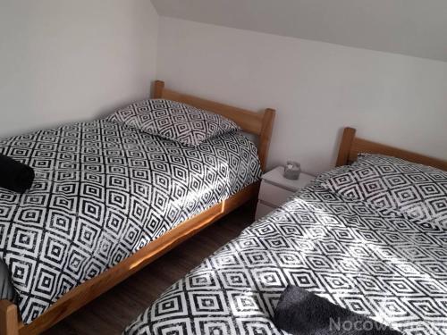 two beds sitting next to each other in a bedroom at Domki na Maciejce Domek dla 15 osób! in Jaworzynka