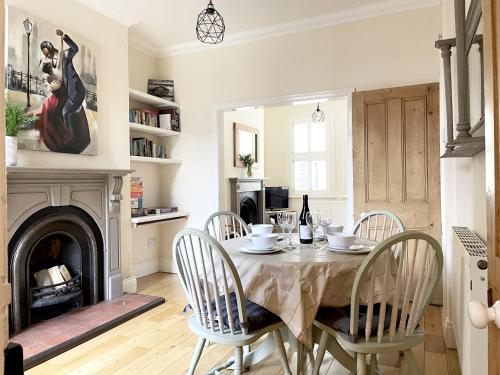 comedor con mesa, sillas y chimenea en Riverside Lodge - Quaint Victorian Home By The River, en York