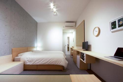 a bedroom with a bed and a desk with a laptop at Sweet Stay Kyoto - Vacation STAY 13383v in Kyoto