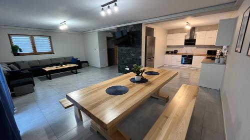 eine Küche und ein Wohnzimmer mit einem Holztisch in der Unterkunft Domki na Maciejce Domek 15 osobowy i 7 osobowy in Jaworzynka