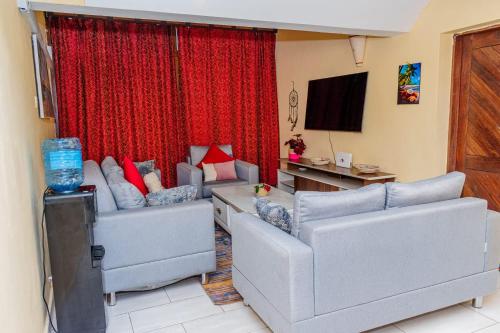 ein Wohnzimmer mit 2 Sofas und einem TV in der Unterkunft Casa bella Beach apartment in Ukunda