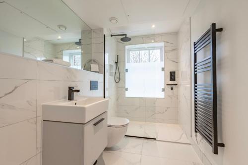 a white bathroom with a toilet and a sink at Apartment 8 - Bootham House in York