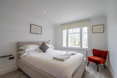 a bedroom with a white bed and a red chair at Apartment 8 - Bootham House in York
