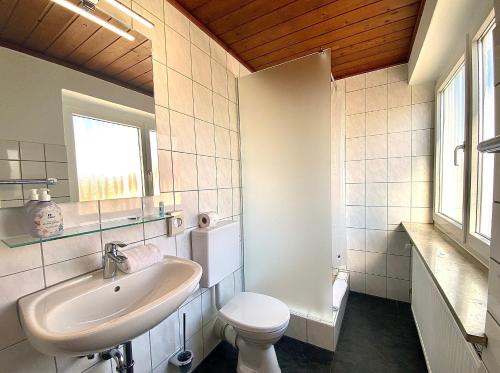a white bathroom with a sink and a toilet at Hotel Gasthof Rose in Günzburg